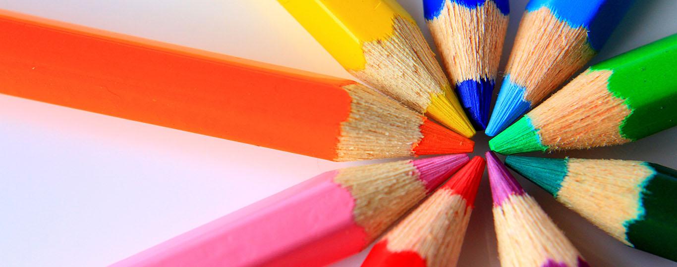 Verschillende kleuren potloden liggen met de punten tegen elkaar