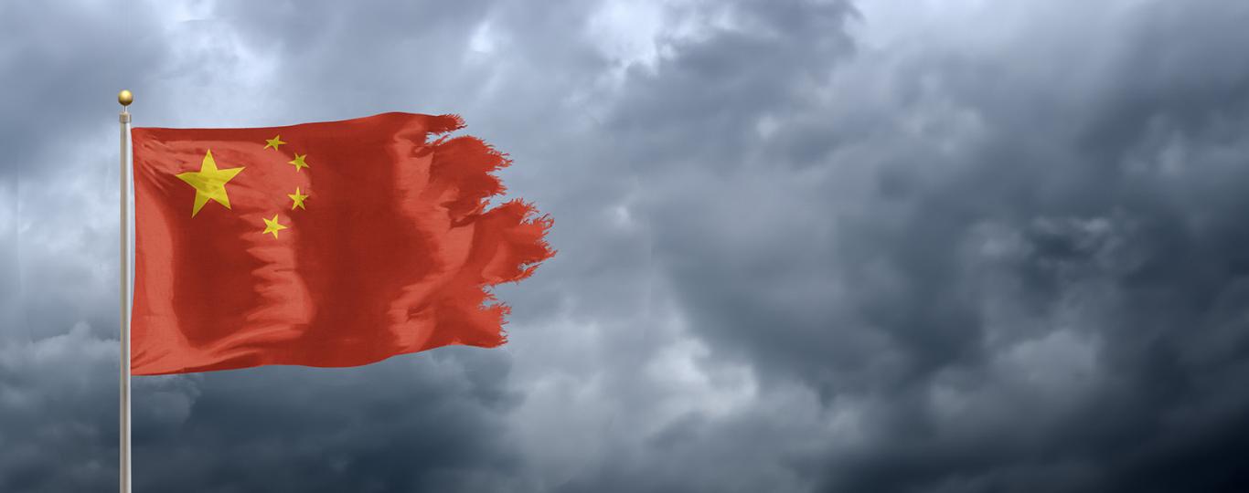 uitgerafelde Chinese vlag wapperen in lucht met donkere wolken