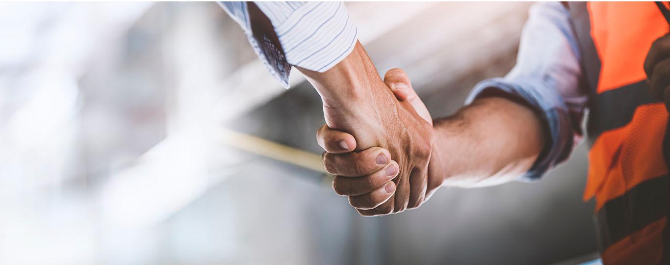 handshake tussen man met hesje en man in maatpak