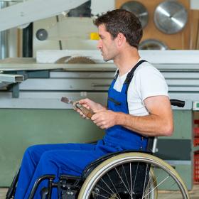 werknemer in rolstoel in schrijnwerkerij