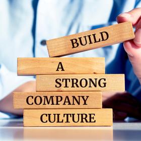 man bouwt torentje met bouwstenen build a strong company culture