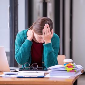 werkneemster met hoofdpijn aan een bureau