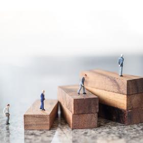 miniatuurpoppeltjes op stijgende stapels houten blokken