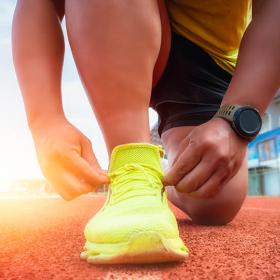 loper bindt veter vast op een atletiekpiste